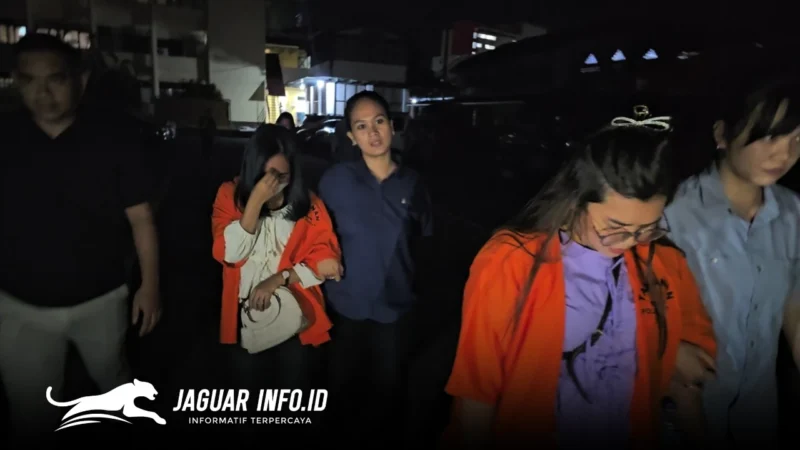 Tersangka korupsi dana kas ATM Bank SulutGo (BSG) Cabang Tahuna berinisial FG dan DM, terlihat mengenakan rompi tahanan saat digiring petugas menuju sel tahanan Mapolda Sulut, Kamis (12/2/2026). Keduanya diduga menyelewengkan dana senilai Rp1,8 miliar. (Foto Istimewa)