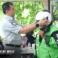 Direktur Utama Jasa Raharja secara simbolis memberikan perlengkapan berkendara dan pihak Jasa Raharja berbagi helm gratis bagi ojol sebagai upaya menekan angka fatalitas di jalan raya. (Foto ; Jasaraharja)