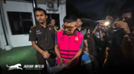 Tersangka IKM (tengah) tampak keluar dari ruang penyidik Kejaksaan Tinggi Sulawesi Utara dengan mengenakan rompi tahanan berwarna merah, Jumat (27/2/2026). Foto Istimewa