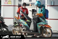 Petugas SPBU melayani pengisian BBM subsidi pada kendaraan roda dua dengan menerapkan verifikasi data melalui sistem digital demi keamanan transaksi.