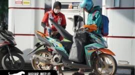 Petugas SPBU melayani pengisian BBM subsidi pada kendaraan roda dua dengan menerapkan verifikasi data melalui sistem digital demi keamanan transaksi.