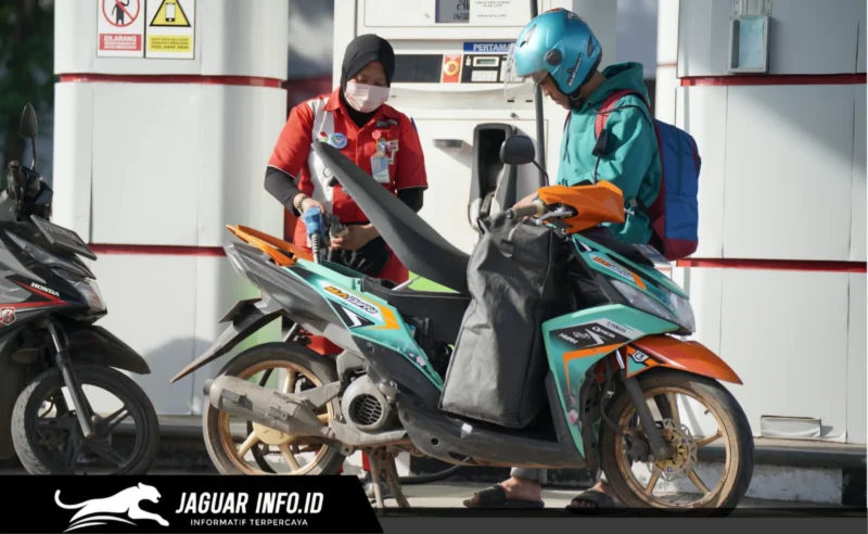 Petugas SPBU melayani pengisian BBM subsidi pada kendaraan roda dua dengan menerapkan verifikasi data melalui sistem digital demi keamanan transaksi.