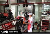 Mekanik ahli di bengkel AHASS sedang melakukan pengecekan rutin untuk memastikan keamanan dan kenyamanan pengendara motor Honda.