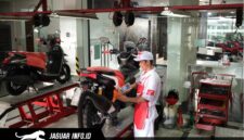 Mekanik ahli di bengkel AHASS sedang melakukan pengecekan rutin untuk memastikan keamanan dan kenyamanan pengendara motor Honda.