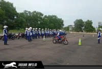 Seorang instruktur safety riding memberikan arahan teknis kepada peserta mengenai teknik engine brake motor yang aman dalam sesi pelatihan praktik