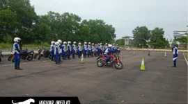 Seorang instruktur safety riding memberikan arahan teknis kepada peserta mengenai teknik engine brake motor yang aman dalam sesi pelatihan praktik