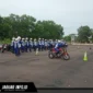 Seorang instruktur safety riding memberikan arahan teknis kepada peserta mengenai teknik engine brake motor yang aman dalam sesi pelatihan praktik