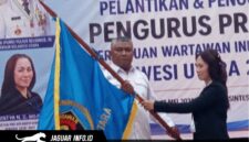 Ketua PWI Sulawesi Utara, Sintya Bojoh, menyerahkan pataka organisasi kepada Hut Kamrin dalam acara pelantikan di Manado.