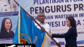 Ketua PWI Sulawesi Utara, Sintya Bojoh, menyerahkan pataka organisasi kepada Hut Kamrin dalam acara pelantikan di Manado.