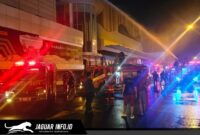 Petugas pemadam kebakaran saat berupaya memadamkan kobaran api di area luar gedung pusat perbelanjaan.