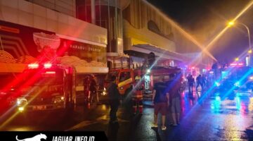 Petugas pemadam kebakaran saat berupaya memadamkan kobaran api di area luar gedung pusat perbelanjaan.
