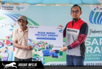 Petugas Integrated Terminal Kendari melayani warga yang menukarkan kupon dengan paket sembako bersubsidi dalam kegiatan pasar murah di Kantor Kecamatan Kendari, Sulawesi Tenggara.