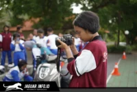 Seorang anak sedang merekam video kreatif menggunakan ponselnya untuk ikut serta dalam kompetisi film pendek.