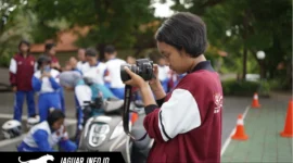 Seorang anak sedang merekam video kreatif menggunakan ponselnya untuk ikut serta dalam kompetisi film pendek.