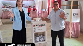 ​Jufri Mantak didampingi istri saat memberikan hak suaranya di Tempat Pemungutan Suara (TPS) Desa Wineru, Kecamatan Kakas, Kabupaten Minahasa, pada 17/06/26.