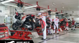Ilustrasi mekanik bengkel sedang memeriksa kondisi shockbreaker sepeda motor untuk memastikan kenyamanan berkendara.