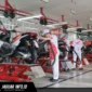 Ilustrasi mekanik bengkel sedang memeriksa kondisi shockbreaker sepeda motor untuk memastikan kenyamanan berkendara.