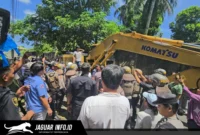 Alat berat ekskavator merobohkan bangunan dua lantai saat berlangsungnya eksekusi lahan Airmadidi di Kabupaten Minahasa Utara, Kamis (06/08/26).