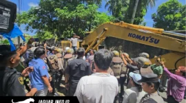 Alat berat ekskavator merobohkan bangunan dua lantai saat berlangsungnya eksekusi lahan Airmadidi di Kabupaten Minahasa Utara, Kamis (06/08/26).