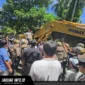 Alat berat ekskavator merobohkan bangunan dua lantai saat berlangsungnya eksekusi lahan Airmadidi di Kabupaten Minahasa Utara, Kamis (06/08/26).