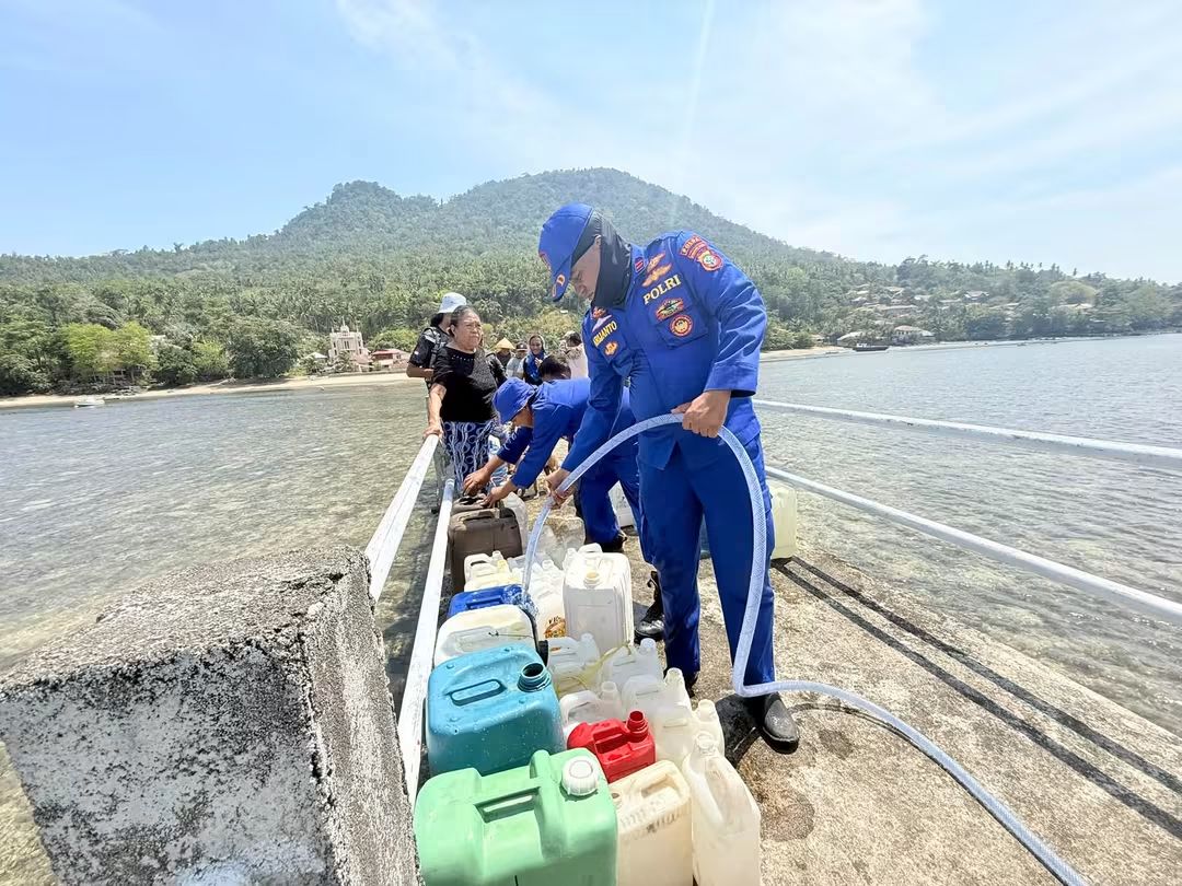 Personel Ditpolairud Polda Sulut dan PDAM Manado mendistribusikan bantuan air bersih menggunakan kapal ikan KM Amazia ke wilayah kepulauan, Kamis (17/09/2026).
