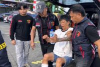 Petugas kepolisian mengawal pelaku pencurian spesialis rumah saat dibawa ke Polresta Manado usai dilumpuhkan saat mencoba melarikan diri di Manado.