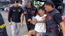 Petugas kepolisian mengawal pelaku pencurian spesialis rumah saat dibawa ke Polresta Manado usai dilumpuhkan saat mencoba melarikan diri di Manado.