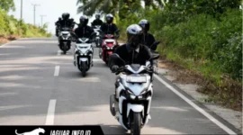 Ilustrasi pengendara motor menggunakan helm bervisual tertutup dan masker sebagai perlengkapan keselamatan saat menghadapi hujan abu vulkanik di jalan raya.