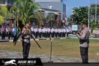 Irjen Pol Roycke Harry Langie menyerahkan Pataka Polda Sulut Maesa'an Waya kepada Kapolda Sulut yang baru, Brigjen Pol Yudo Hermanto, di Lapangan Presisi Mapolda Sulut.