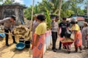 Kapolsek Wori bersama personel dan warga Desa Kima Bajo bergotong royong menimbun tanah ambles di sekitar sumur air.