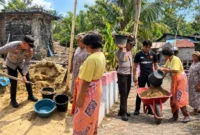 Kapolsek Wori bersama personel dan warga Desa Kima Bajo bergotong royong menimbun tanah ambles di sekitar sumur air.