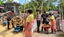 Kapolsek Wori bersama personel dan warga Desa Kima Bajo bergotong royong menimbun tanah ambles di sekitar sumur air.