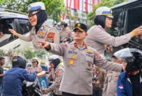 Personel Polda Sulut membagikan air mineral kepada pengendara yang mengantre BBM serta melakukan pengamanan di sejumlah SPBU di Kota Manado, Jumat (16/10/2026).