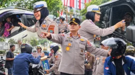 Personel Polda Sulut membagikan air mineral kepada pengendara yang mengantre BBM serta melakukan pengamanan di sejumlah SPBU di Kota Manado, Jumat (16/10/2026).