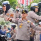 Personel Polda Sulut membagikan air mineral kepada pengendara yang mengantre BBM serta melakukan pengamanan di sejumlah SPBU di Kota Manado, Jumat (16/10/2026).