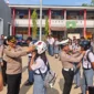 Kapolres Minahasa Tenggara AKBP Handoko Sanjaya bersama Kasatlantas Iptu Nicky Pondalos saat berbagi helm berstandar SNI kepada siswa SMKN 1 Ratahan, 27/10/2026.