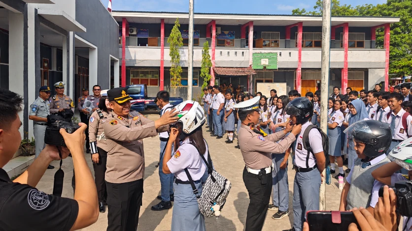 Kapolres Minahasa Tenggara AKBP Handoko Sanjaya bersama Kasatlantas Iptu Nicky Pondalos saat berbagi helm berstandar SNI kepada siswa SMKN 1 Ratahan, 27/10/2026.
